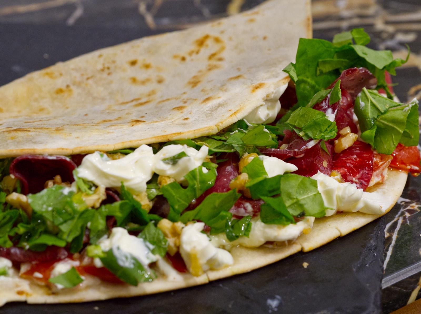 Piadina artigianale M'Arricrio farcita con bresaola, stracciatella, rucola e noci